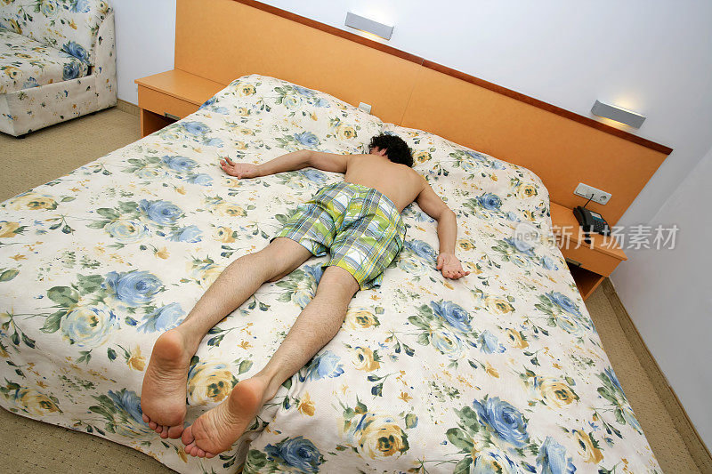 一个疲倦的(生病的/喝醉的)人躺在旅馆的床上